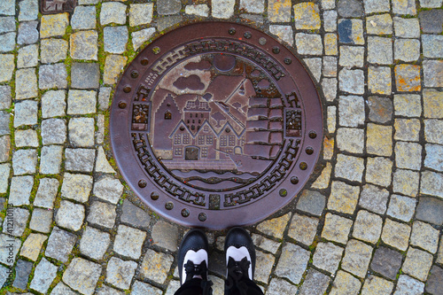 Hatchway on the cobblestone street and shoes on it. Bergen, Norway photo