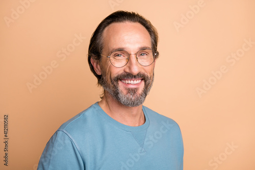 Photo portrait of confident man in glasses isolated on pastel beige colored background © deagreez