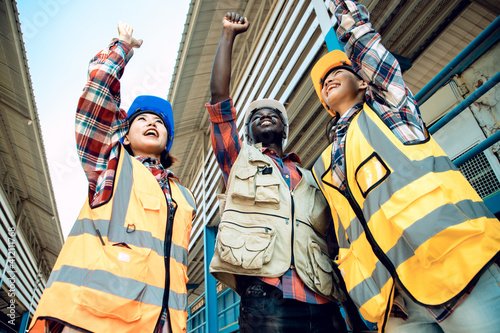 Engineers working on train garage site and holding hands to successful big project. Portrait of positive thinking of engineering teamwork. Happiness and Industry concept