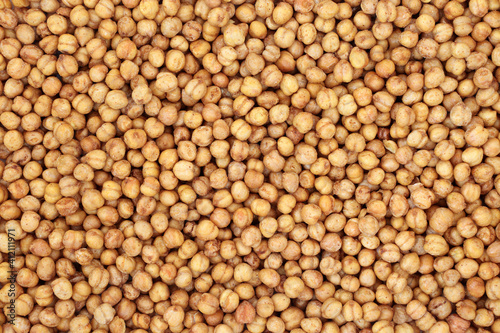 Roasted spicy & salted vegan chickpeas forming a background. Healthy food high in dietary fibre, protein, vitamins and minerals. Flat lay.