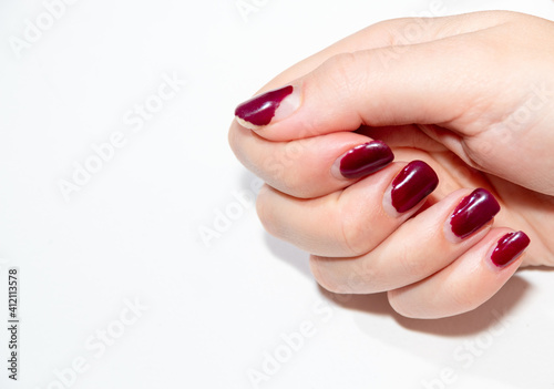 Fingers with a damaged, broken, half-inch coating of gel polish. Selective focus. Close-up. White background.