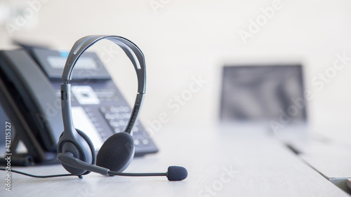 Communication support, call center and customer service help desk. VOIP headset on telephone keyboard.