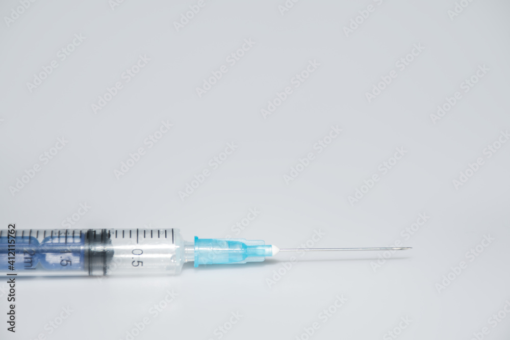 One syringe with a different dose of medicine or vaccine on a white or gray background with a place for the text: vaccinations against influenza coronavirus, side view One syringe with a different dose of medicine or vaccine on a white or gray background with a place for the text: vaccinations against influenza coronavirus, side view
