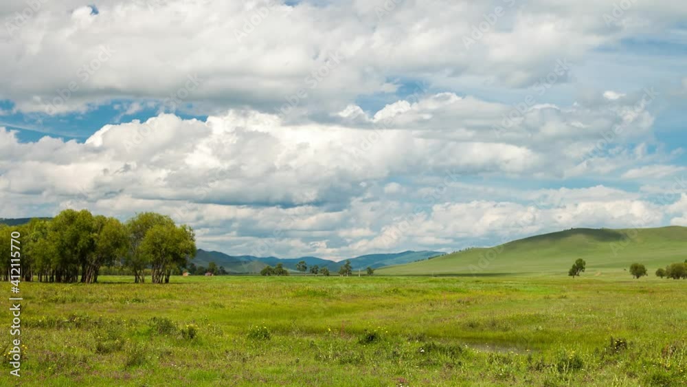 Timelapse in the blue sky, clouds float over the mountains and a plain with trees Timelapse in the blue sky, clouds float over the mountains and a plain with trees