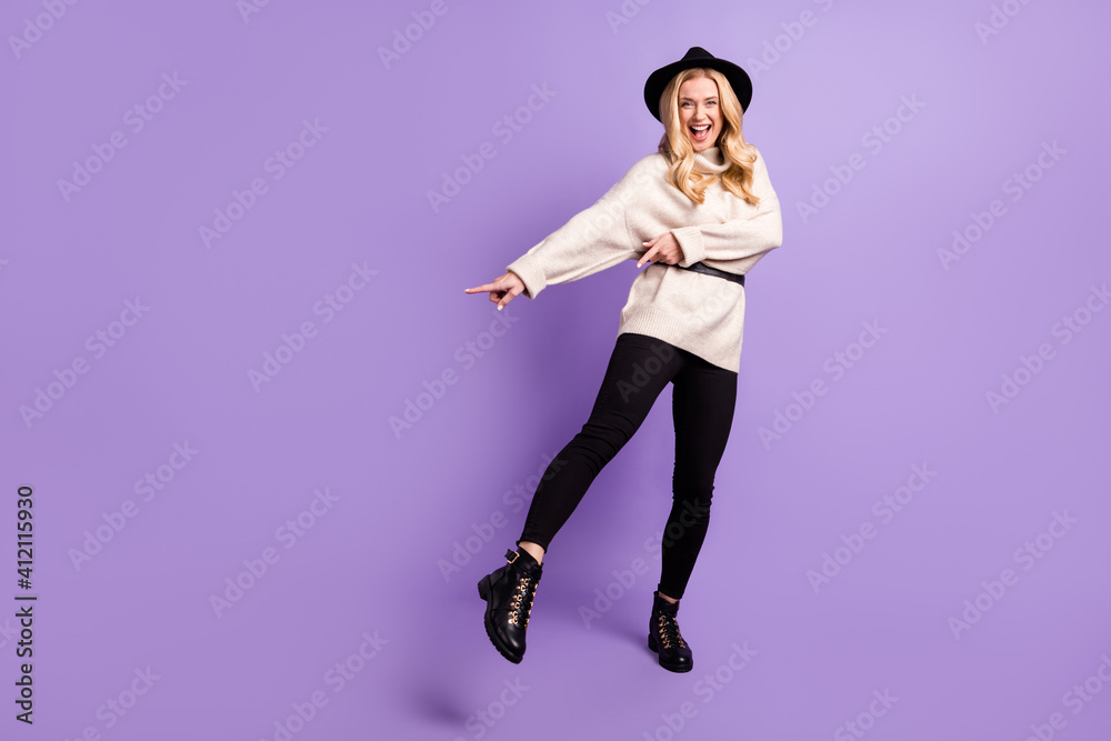 Full body photo of excited happy nice woman point finger empty space dance isolated on violet color background