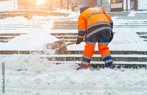 Snow removal. A worker cleans snow with a shovel after a snowfall at gatherings photo