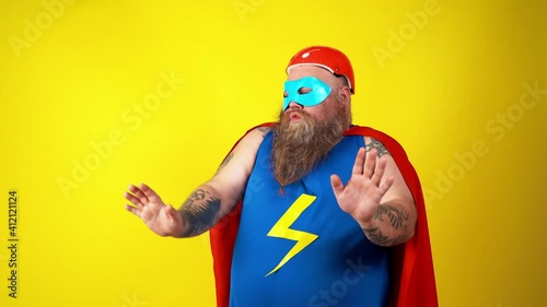 Chubby super hero in action. Masked hipster man on colored background