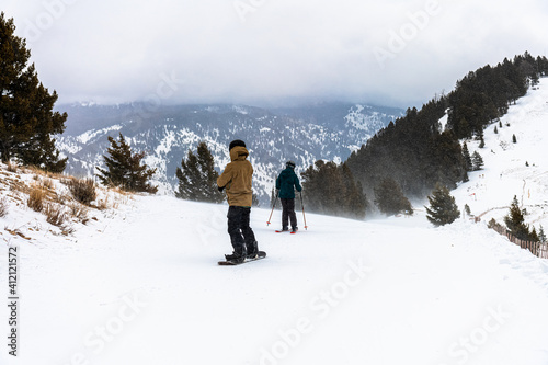 Two men snow riding from top of the mountain, Jackson Hole, Wyoming, USA. Heavy snow winter weather