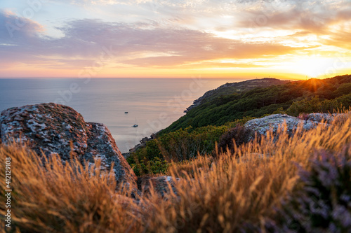 Golden sunset over mountains and sea at Kullaberg nature reserve in south Sweden. photo
