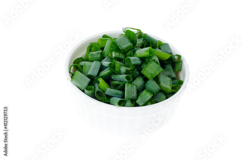 Bowl with slices of chopped green onions for preparing healthy dishes.
