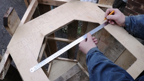 Foto a carpenter measures the distance and size of a hole in a wooden structure with