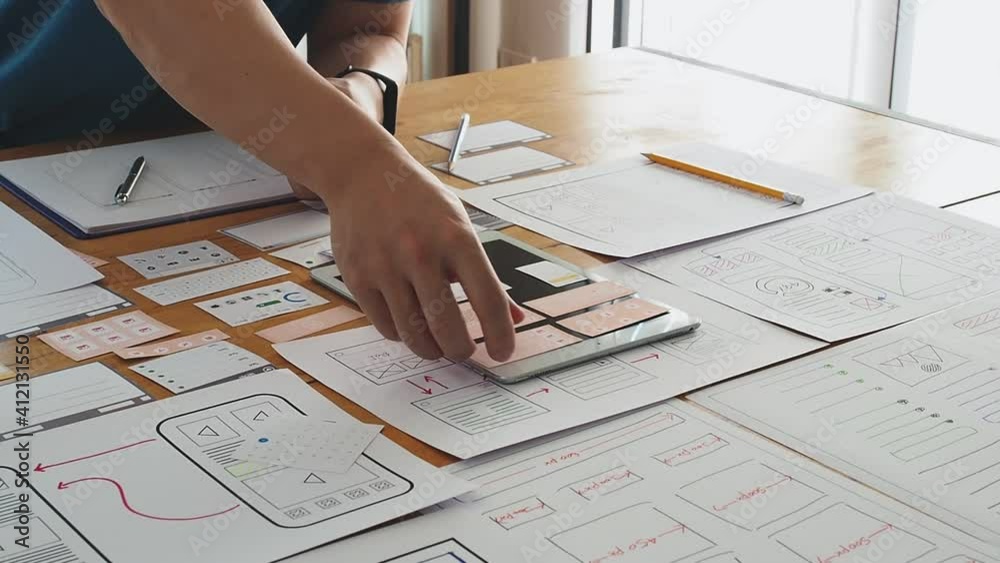 UX or UI designer designing application on tablet with mockup layout prototype.