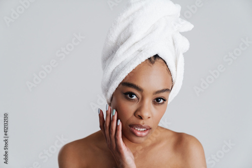 Shirtless african american woman in bath towel touching her face