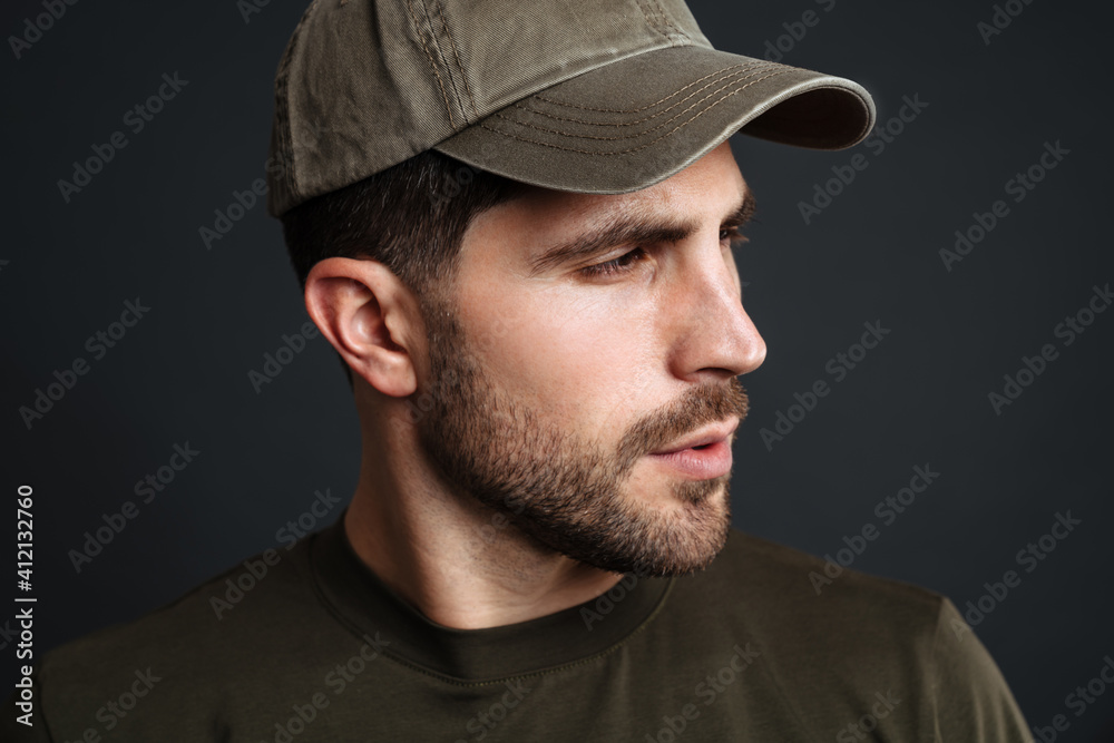 Focused masculine military man posing and looking aside Focused masculine military man posing and looking aside