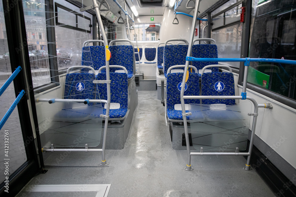 Obraz premium Empty bus interior. Blue seats without passengers. Public transport. Transportation of passengers by public transport. Ergonomic interior of the bus. Travel to other cities.