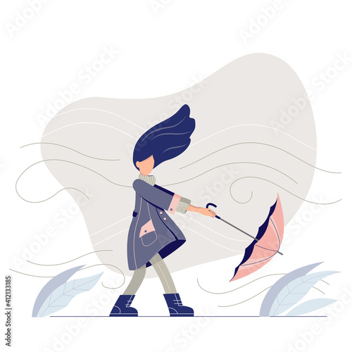 A stylish girl walking in a windy day. Young woman in a trendy coat with umbrella. 