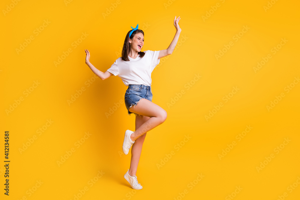 Full length body size view of slender lovely cheerful brown-haired girl jumping dancing isolated over bright yellow color background