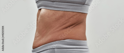 Foto Crumpled skin on waistline of slim middle aged woman
