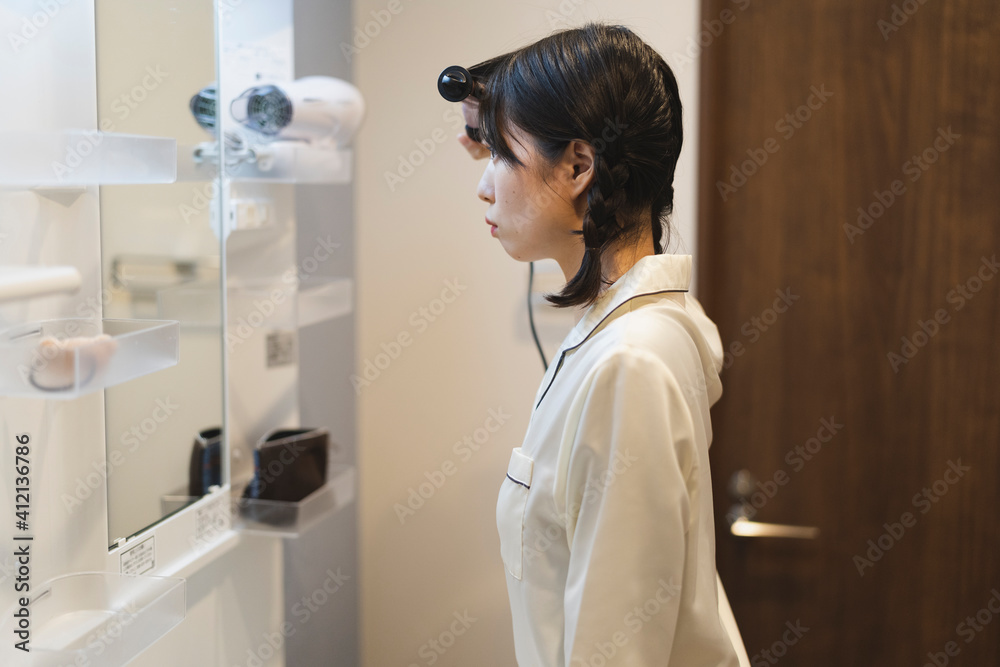 朝のヘアメイクをする女性 朝のヘアメイクをする女性