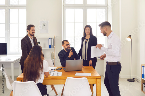 Group of positive business people coworkers discussing new project or startup together