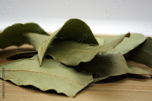 Bay leaf on a wooden and white background.