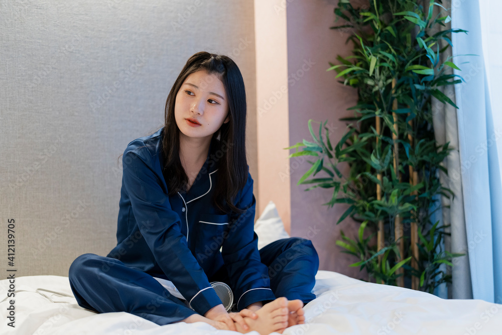 ベッドでリラックスしたパジャマの女性