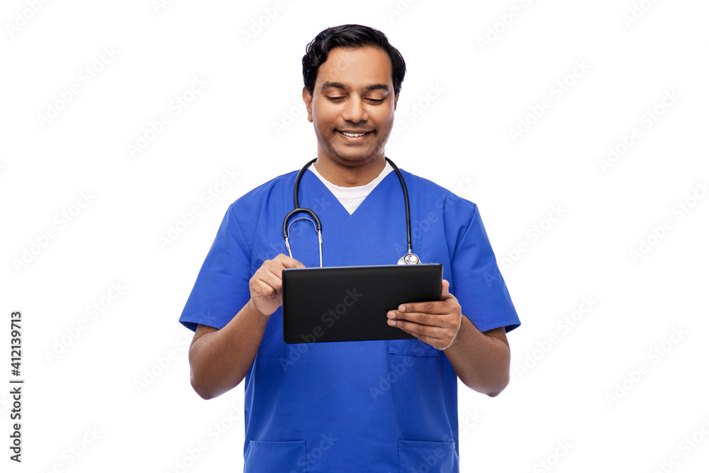 medicine, healthcare and technology concept - happy smiling indian doctor or male nurse in blue uniform with stethoscope using tablet pc computer over white background medicine, healthcare and technology concept - happy smiling indian doctor or male nurse in blue uniform with stethoscope using tablet pc computer over white background