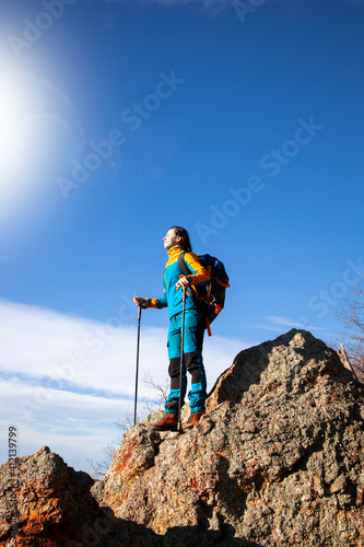 Beautiful female feeling the sun on her face in the mountains