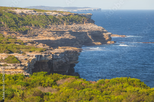 Rocky, cliff seafront coastline and heathland in the Royal National Park on a sunny summer day in the eastern suburbs of Sydney, NSW, Australia. photo