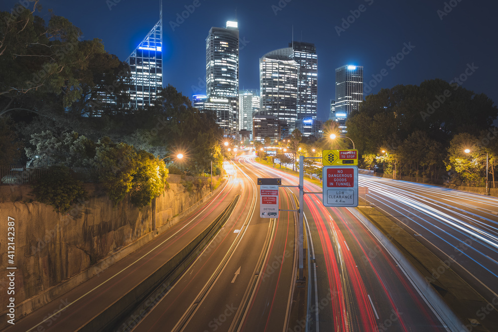 Fototapeta premium Summer night cityscape view of the M1 motorway and Eastern Distributor and downtown Sydney central business district (CBD) city skyline from Art Gallery Rd. in NSW.