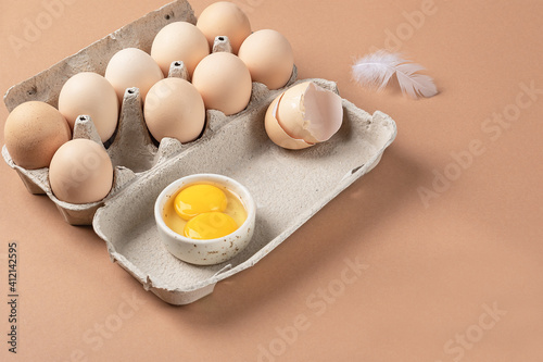 two yolks in one egg. Open carton with farm eggs and eggshells

