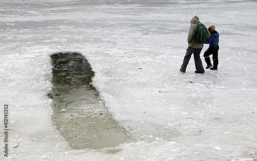 Children walk on the ice of a frozen lake