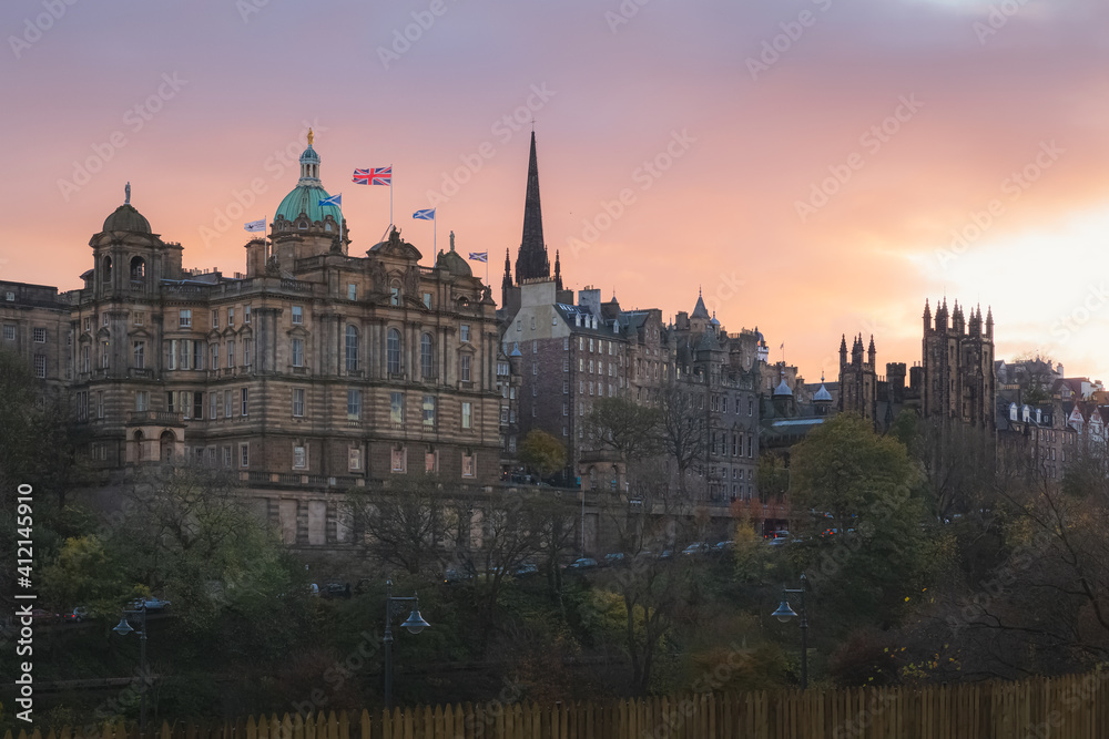 A view of Museum on the Mound, Ramsay Garden, Edinburgh Castle and Old Town Edinburgh cityscape skyline at sunset or sunrise from Waverley Station.