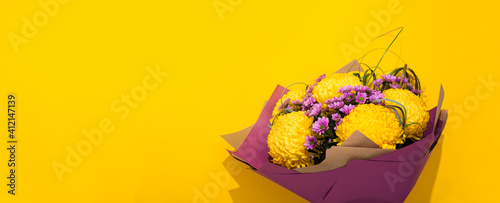 Banner with lush chrysanthemums bouquet on bright yellow background with copy space, empty text place. Flower shop certificate. Holiday greeting card Valentine and Mother day, International Woman Day