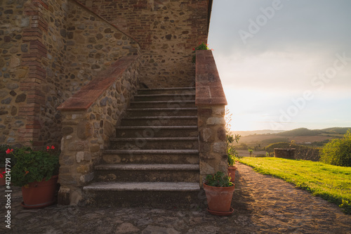 Steps up to a rustic stone countryside farmhouse near Radicondoli in the province of Siena in Tuscany, Italy.
