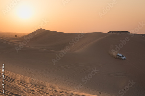 A 4x4 sport utility vehicle bashing sand dunes at sunset on a tourist desert safari in the Empty Quarter Desert  Rub  al Khali  near Abu Dhabi  UAE.