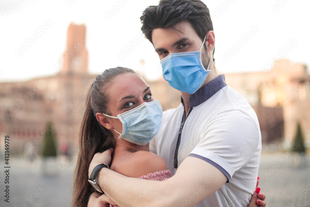 Couple with mask embracing outdoor
