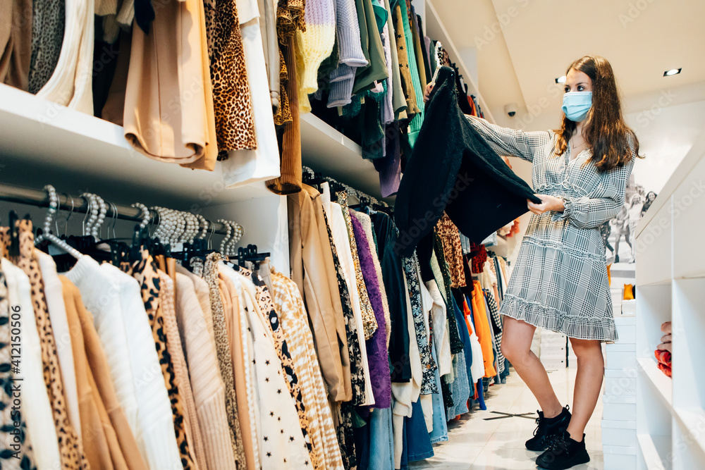 female customer clothes shopping in a fashion store. Young woman browsing dresses in the shop. female customer clothes shopping in a fashion store. Young woman browsing dresses in the shop.