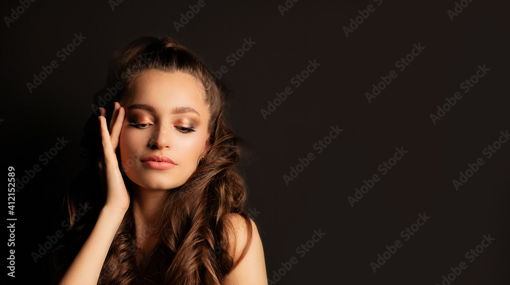 Glamorous brunette model posing at black background Glamorous brunette model posing at black background