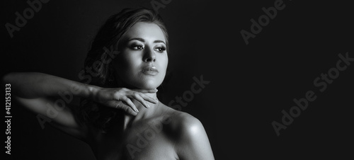 Stunning woman with naked shoulders posing in the dark © vpavlyuk