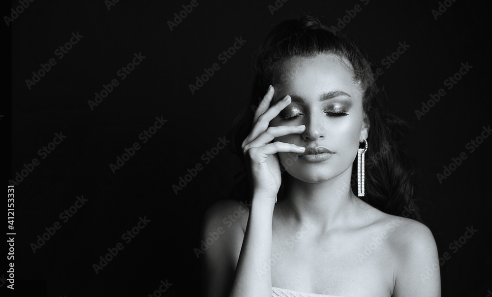 Stylish woman with naked shoulders posing in the dark Stylish woman with naked shoulders posing in the dark