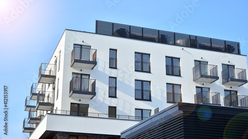 Modern apartment buildings on a sunny day with a blue sky. Facade of a modern apartment building.Glass surface with sunlight. © Grand Warszawski