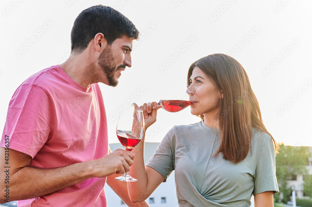 portrait of young couple having a glass of wine at sunset portrait of young couple having a glass of wine at sunset
