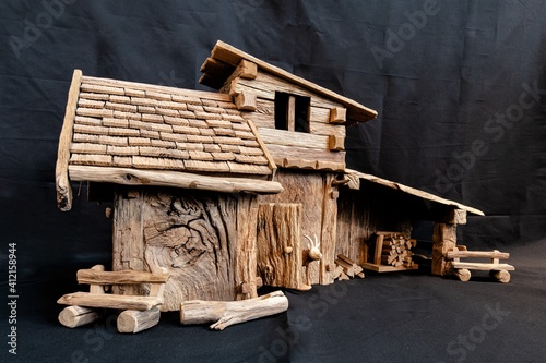 Ein originalgetreu aus Altholz  nachgebautes Model eines  Almhauses mit Stall, Bänken und einer Tränke photo