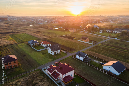 Aerial view of private homes in rural suburban area at sunset.