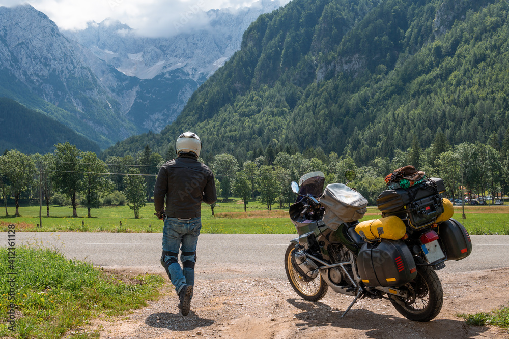 Motorcyclist man and Adventure Motorbike with bags. Motorcycle trip. World Traveling, Lifestyle Travel vacations sport outdoor concept. Zgornje Jezersko Slovenia