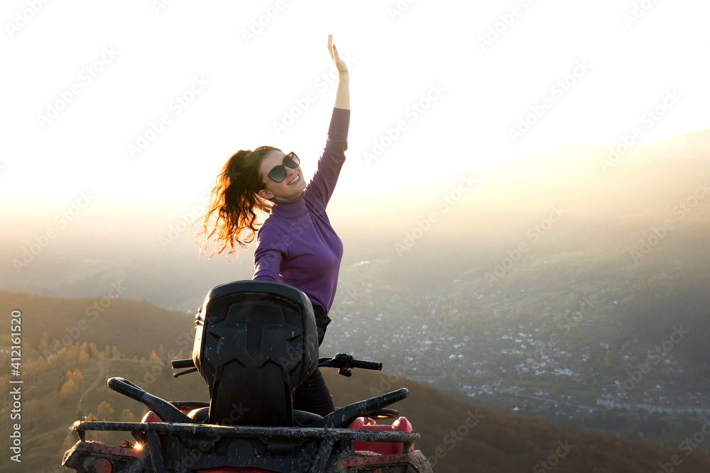 Young happy woman enjoying extreme ride on atv quad motorbike in autumn mountains at sunset. Young happy woman enjoying extreme ride on atv quad motorbike in autumn mountains at sunset.