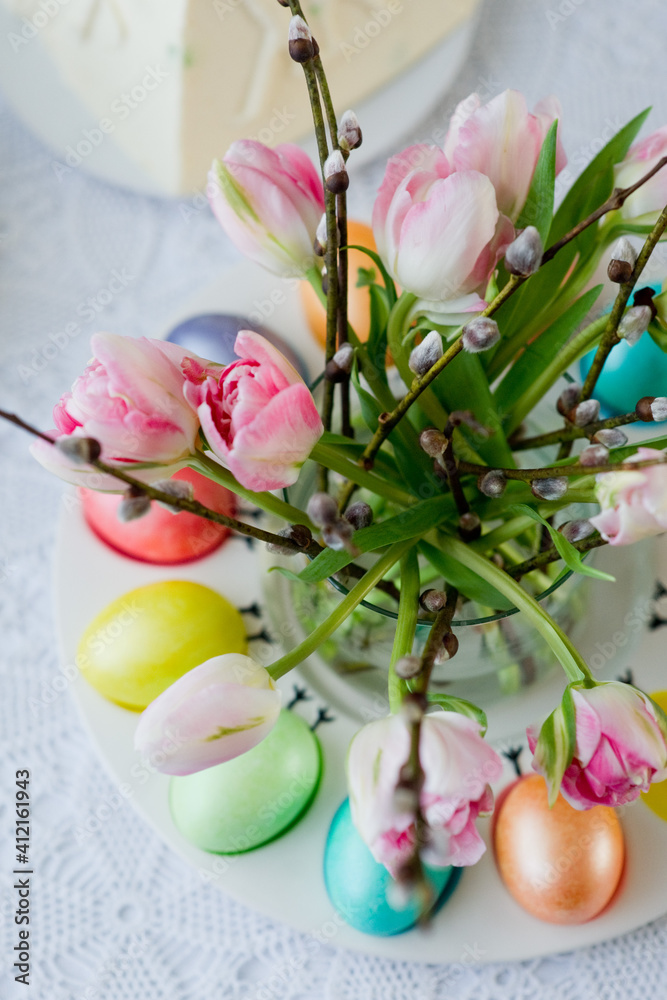 Easter still life with a bouquet of tulips and willow, Easter eggs and cake in pastel colors