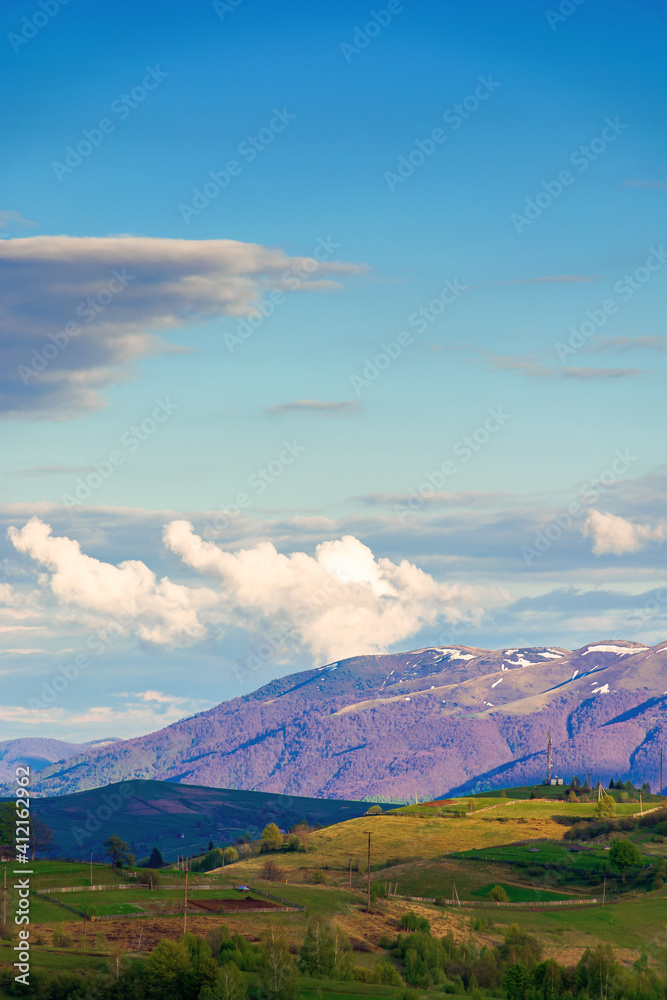 mountainous rural landscape in springtime. beautiful scenery beneath a sky with clouds. grass covered hill rolling in to the distant ridge