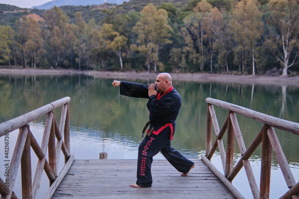 man practicing sipalkido discipline outdoors in a lake in a sunny day